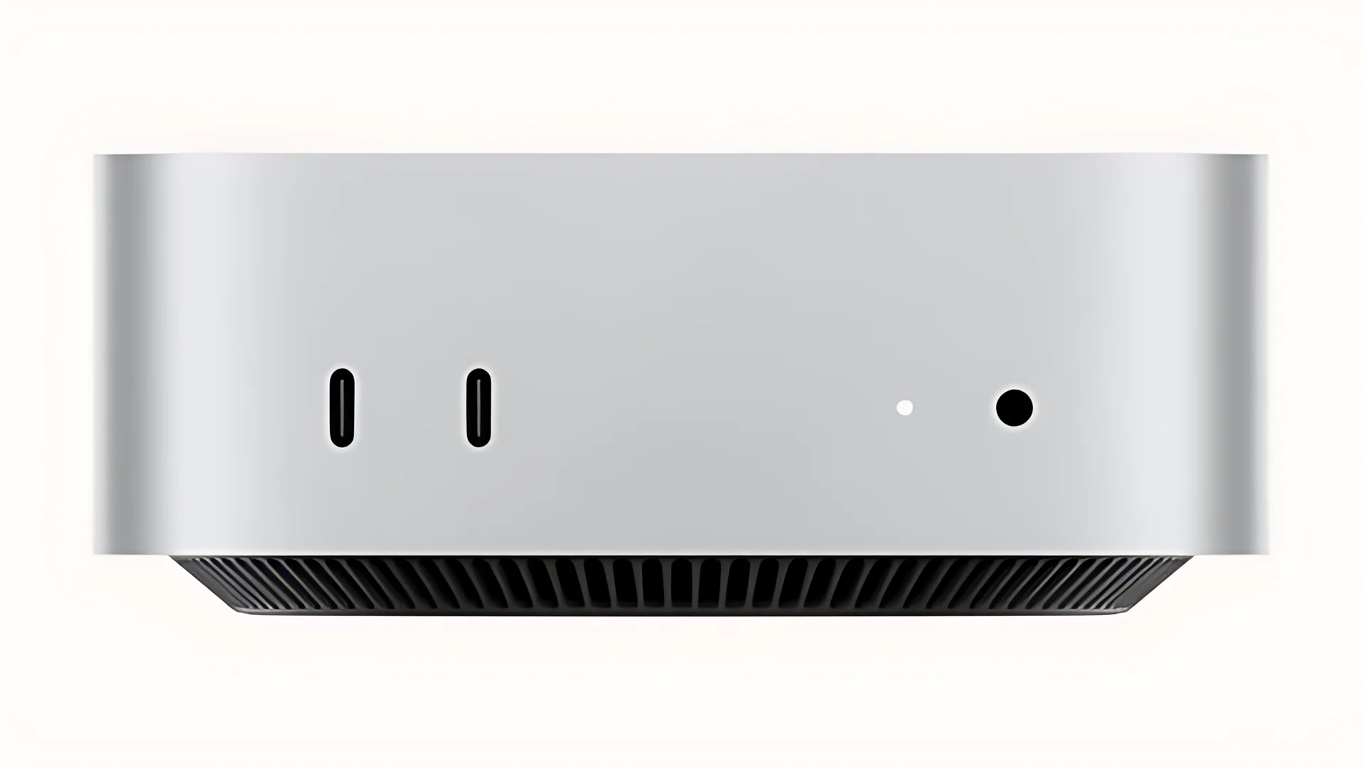 A top-down view of a silver Mini PC with two ports and a small light on the back.
