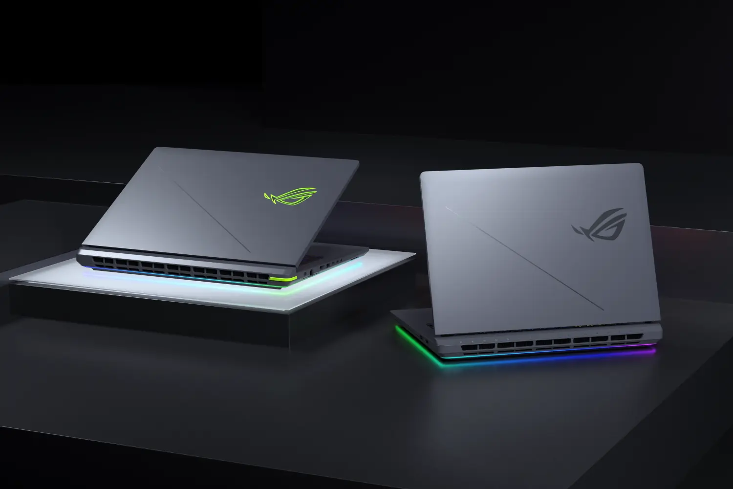 Two ASUS ROG Strix G16 laptops are shown from a three-quarter angle, highlighting their sleek design and illuminated RGB lighting.