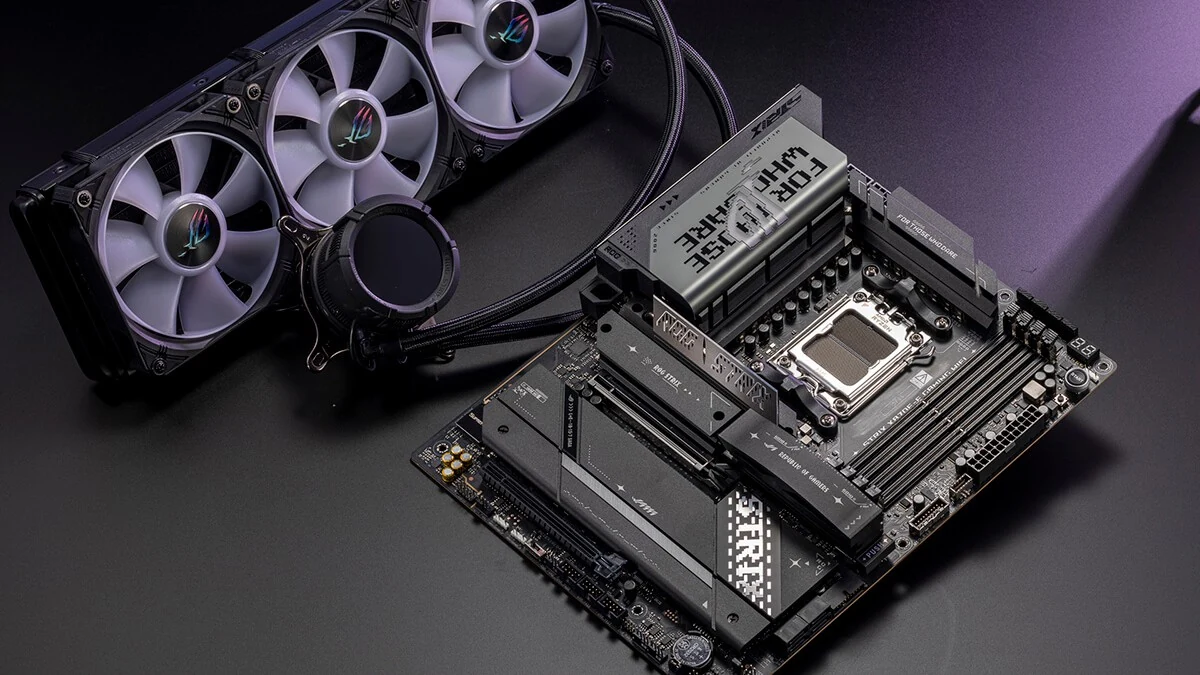 A top-down view of an ASUS ROG Strix X870E-E Gaming motherboard with a cooling fan placed beside it.