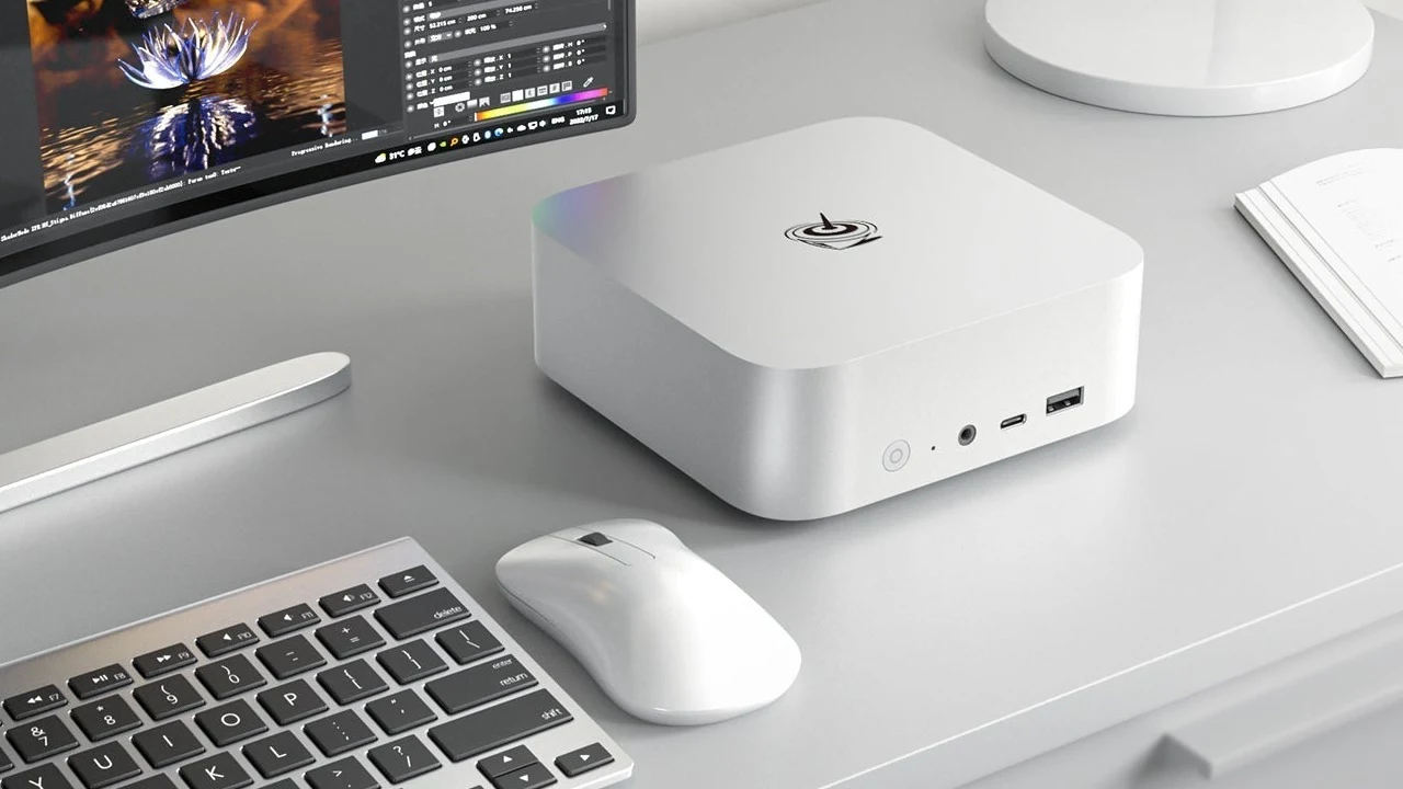 Beelink SER8 mini PC on a white desk next to a monitor, keyboard and mouse