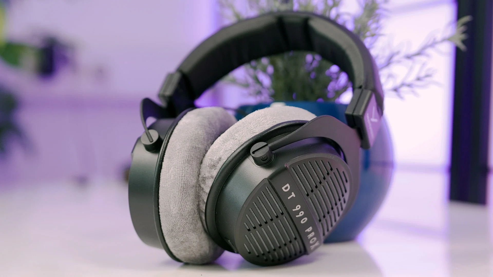The image shows a Beyerdynamic DT 990 PRO headset in a side profile, with the ear cups and headband clearly visible.