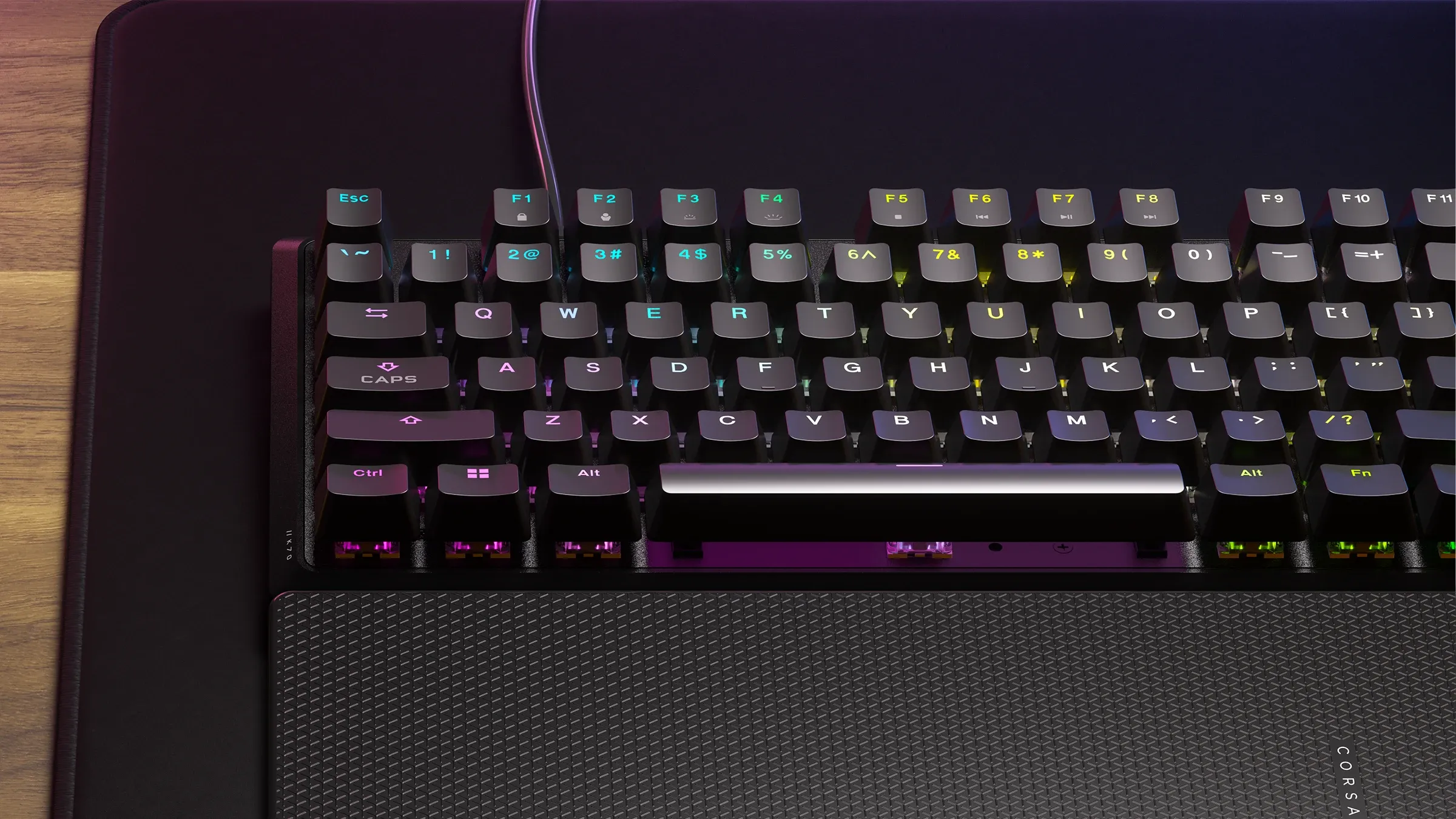 The keyboard is shown from a top-down angle with RGB lighting on the keys and a textured palm rest.