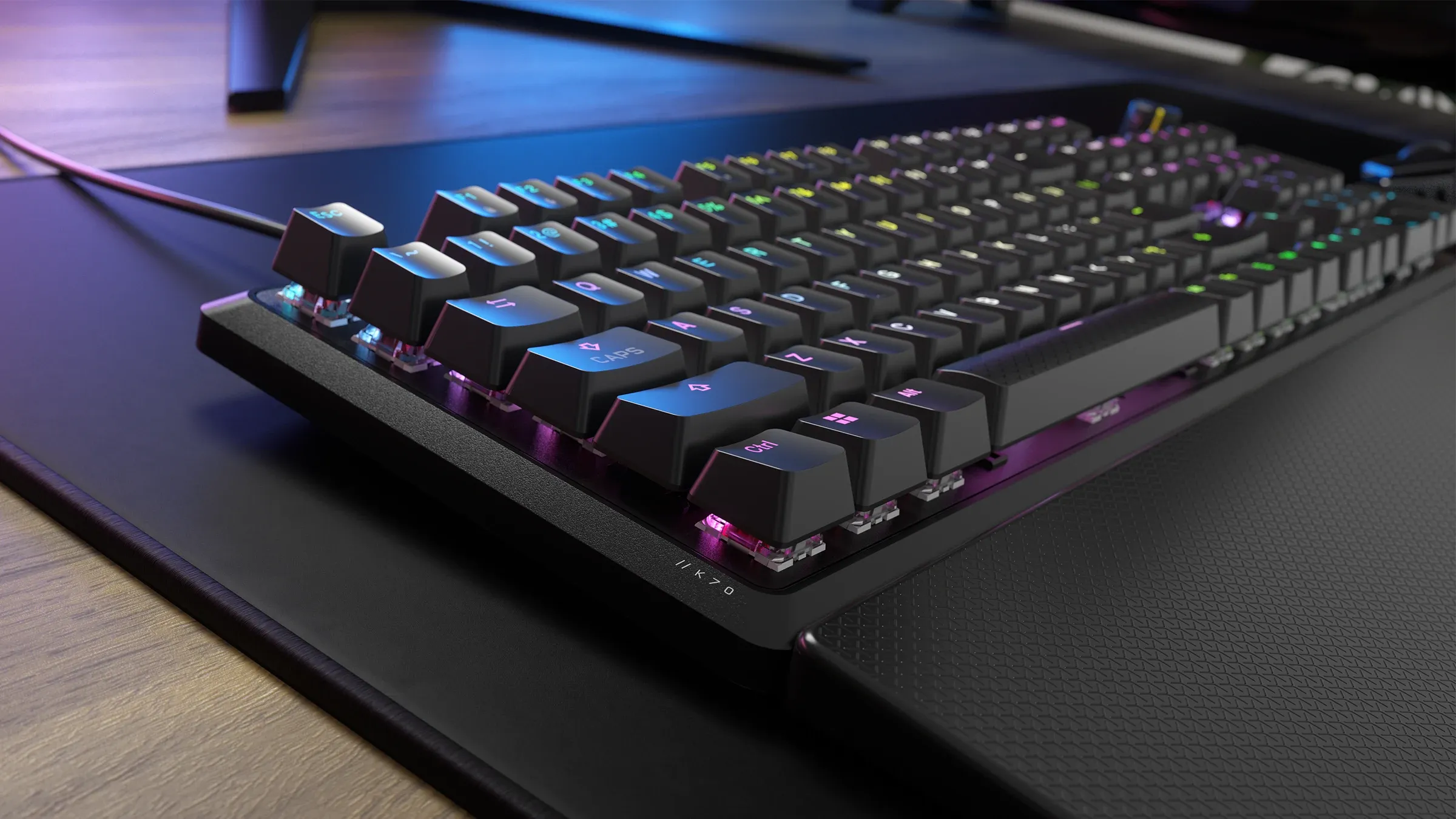A side profile of a Corsair K70 CORE RGB keyboard on a desk, showing its black finish and illuminated keys.