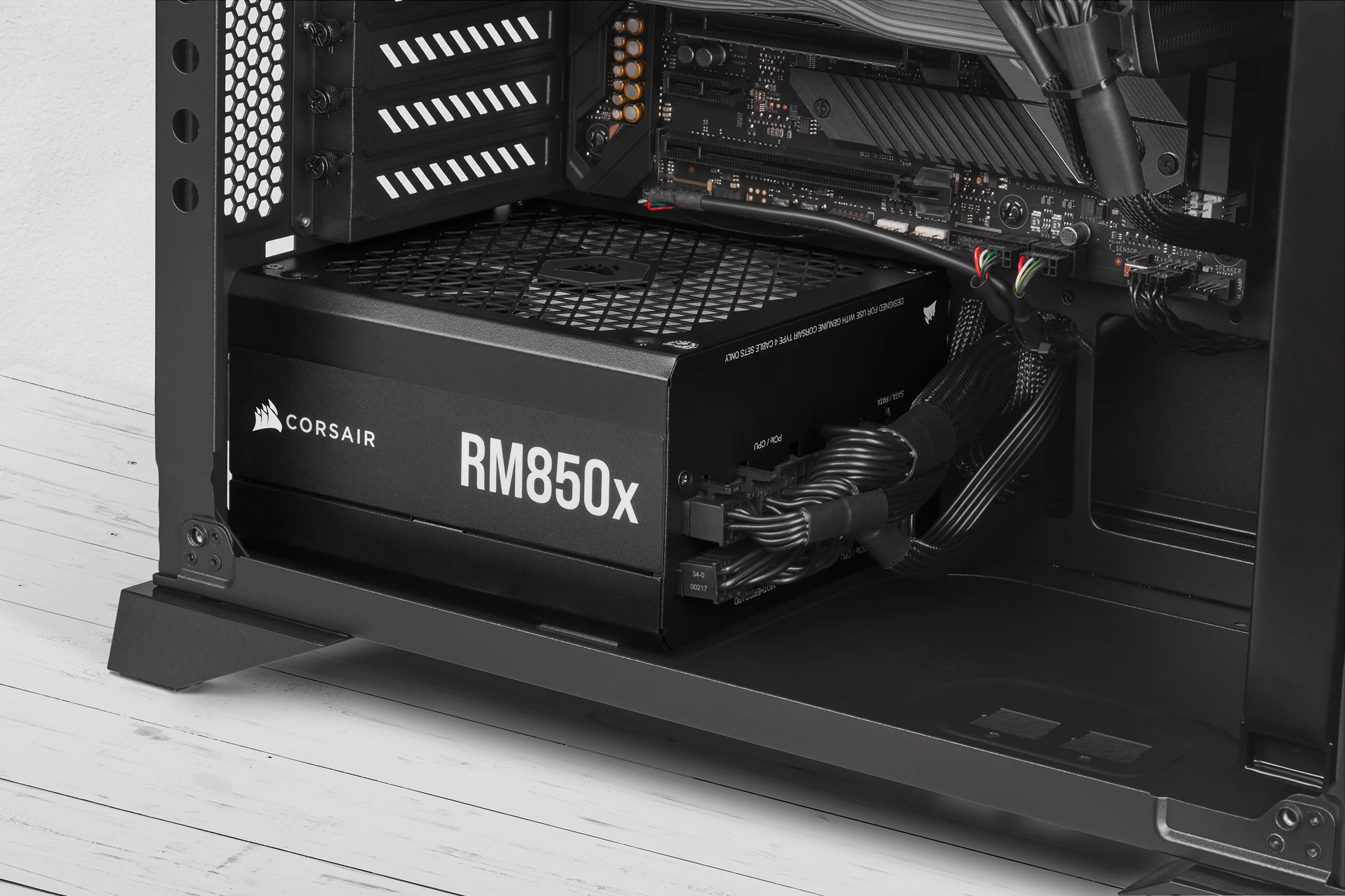 The Corsair RM850x power supply is shown in a side profile, installed inside an open computer case with cables and other components visible.
