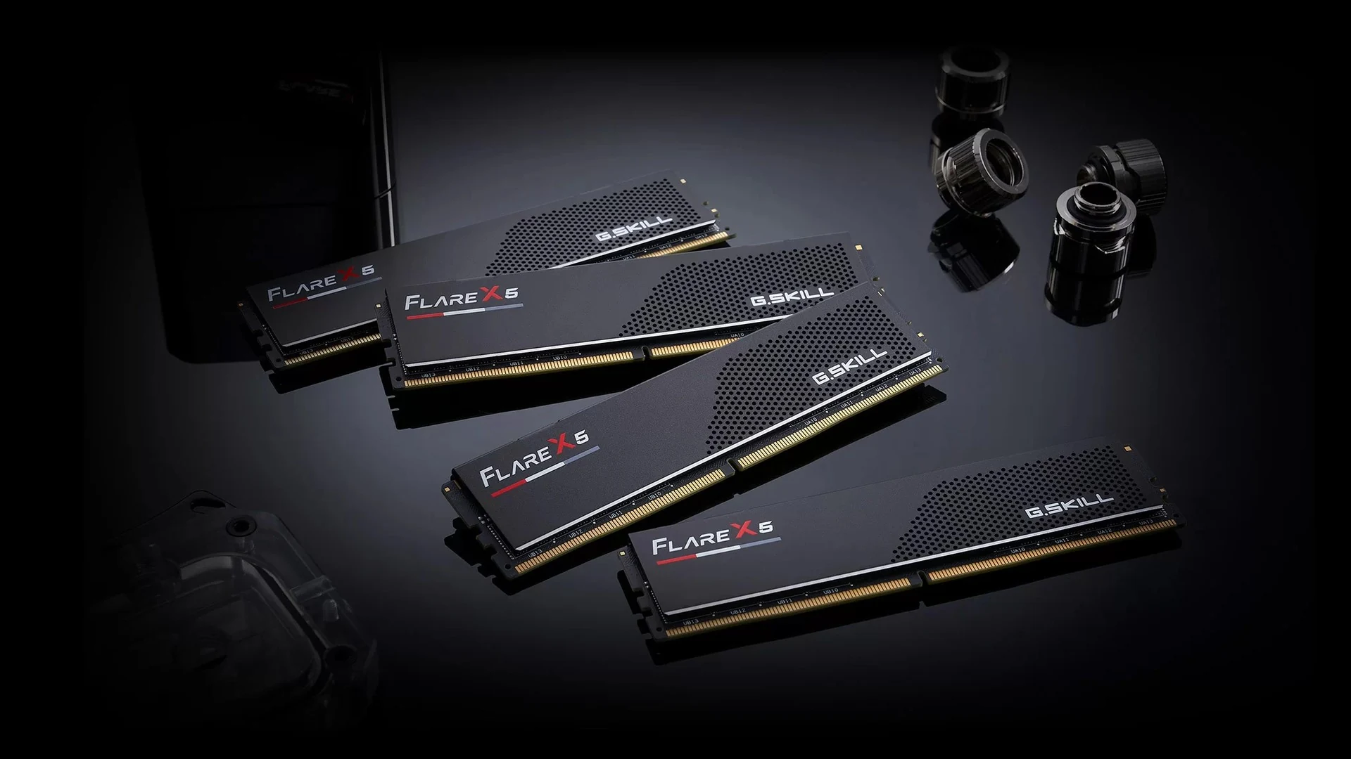 The image shows four G.SKILL Flare X5 Series DDR5 memory modules arranged on a reflective black surface with some black plastic components in the background.