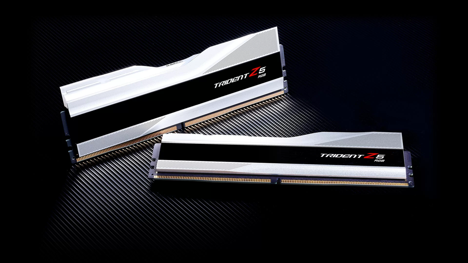 The image shows two memory modules of the G.SKILL Trident Z5 RGB Series DDR5, positioned side by side against a dark textured background.