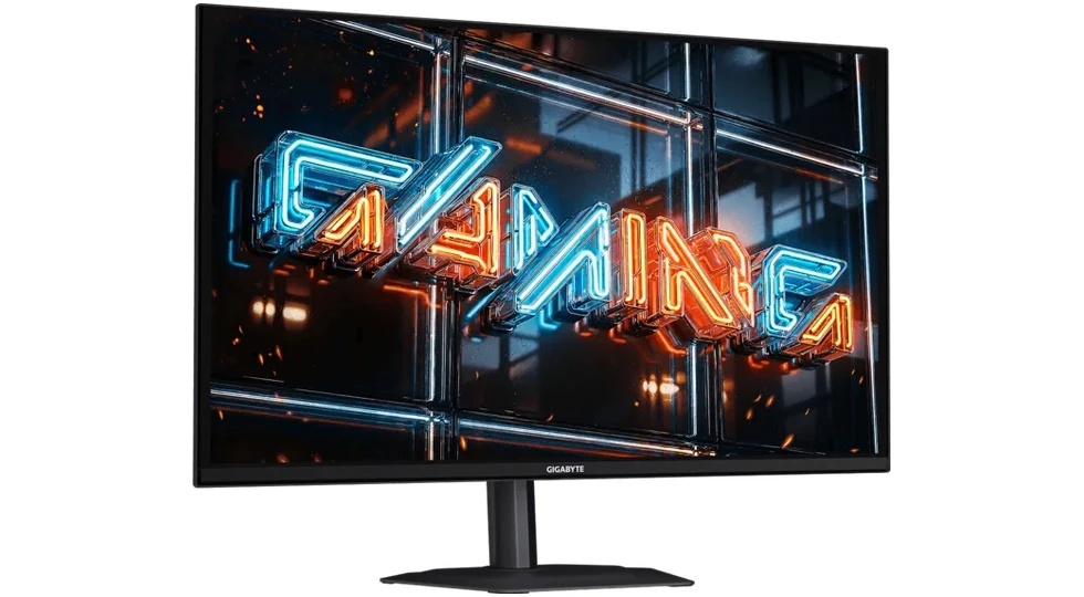 The Gigabyte GO27Q32 monitor on its stand, seen from the front left with a neon "Gaming" graphic on screen.