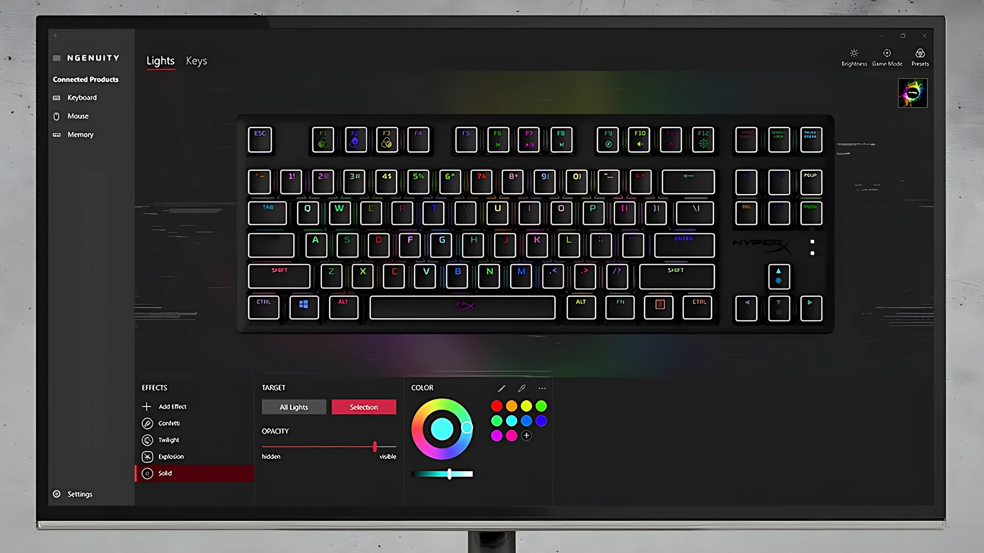 The image shows a black HyperX Alloy Origins Core keyboard displayed on a monitor with RGB lighting effects visible through the keys.