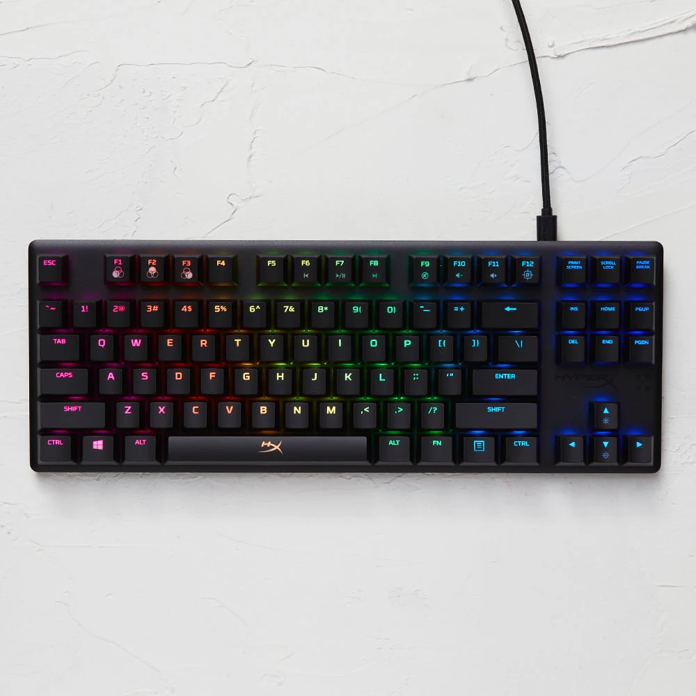 A black HyperX Alloy Origins Core keyboard with RGB backlighting, viewed from a top-down angle.