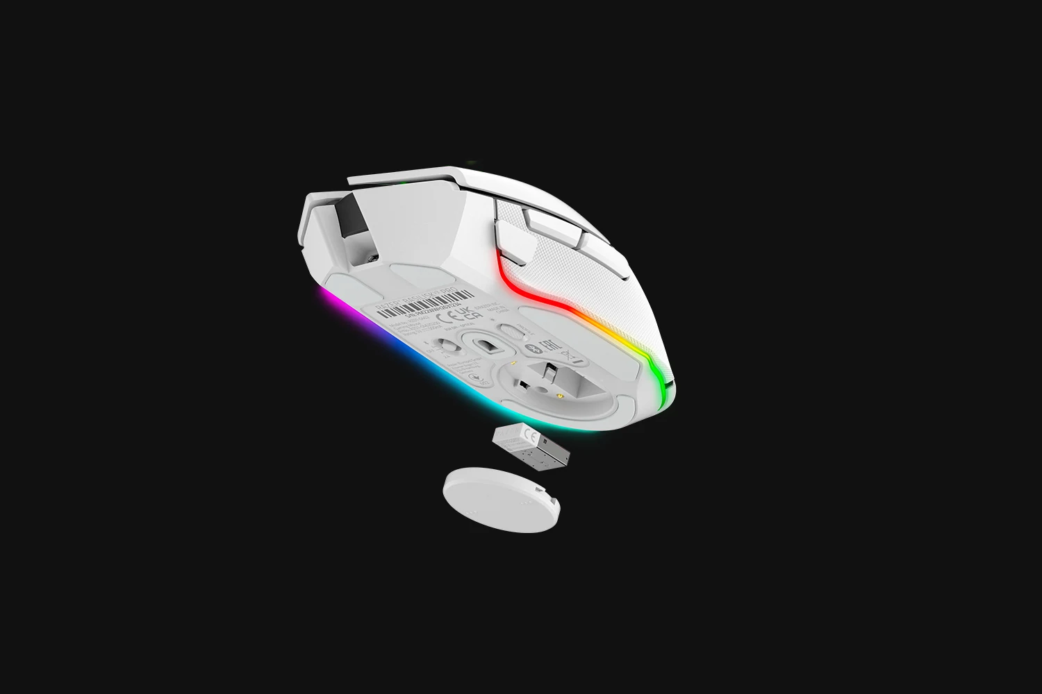 A white gaming mouse with a side profile view, showing the underside and RGB lighting.