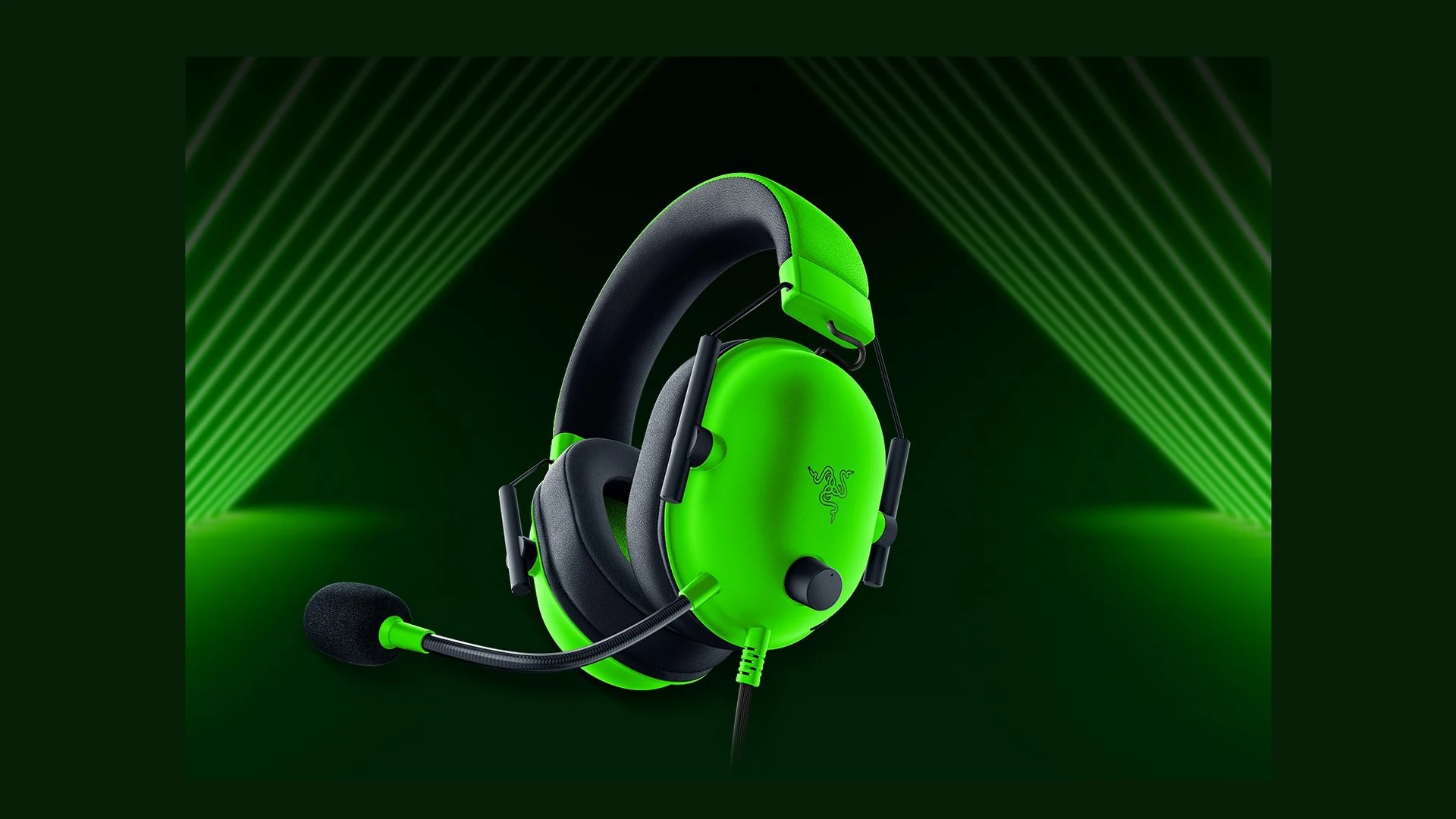 A close-up of a green and black Razer BlackShark V2 X headset with a microphone.