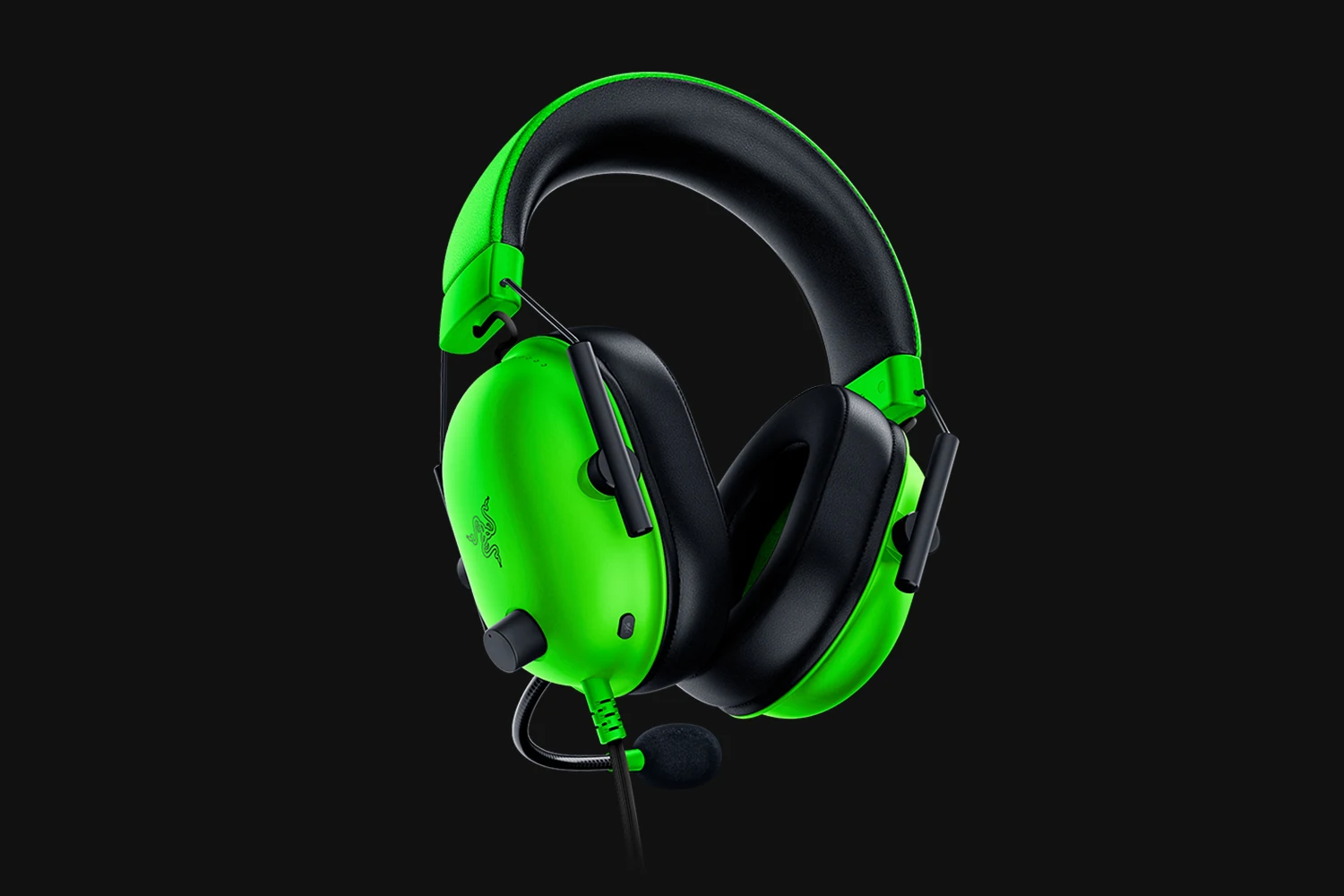 A close-up of a green and black Razer BlackShark V2 X headset with a microphone.