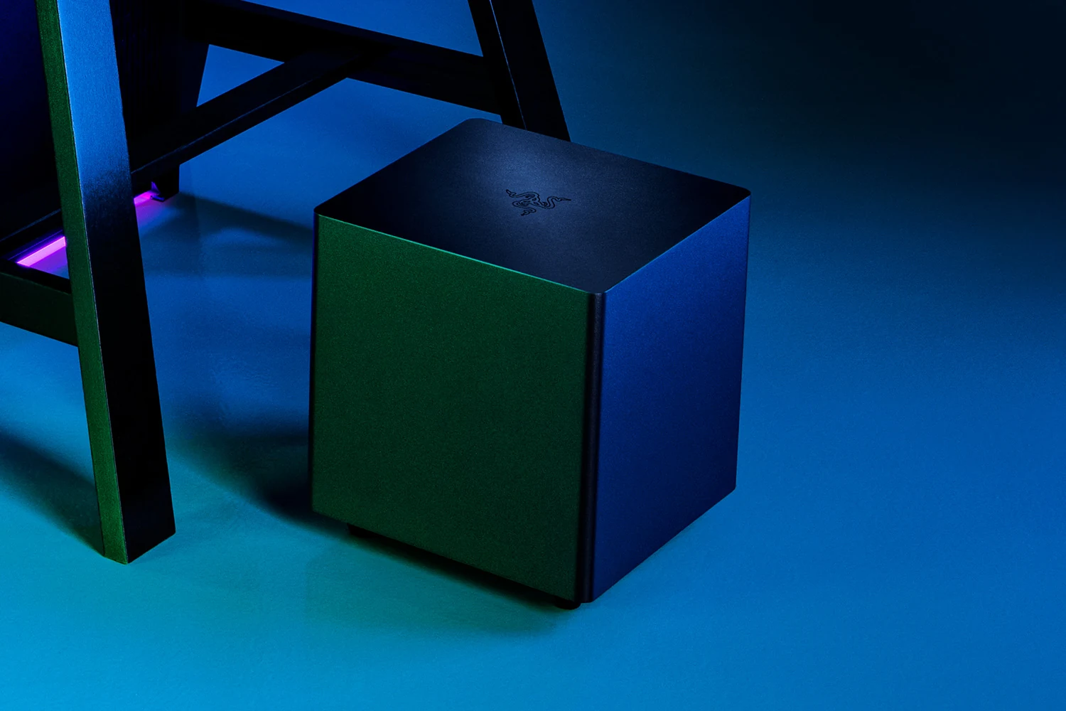 A dark green and black Razer speaker with a textured surface, photographed from a three-quarter angle.