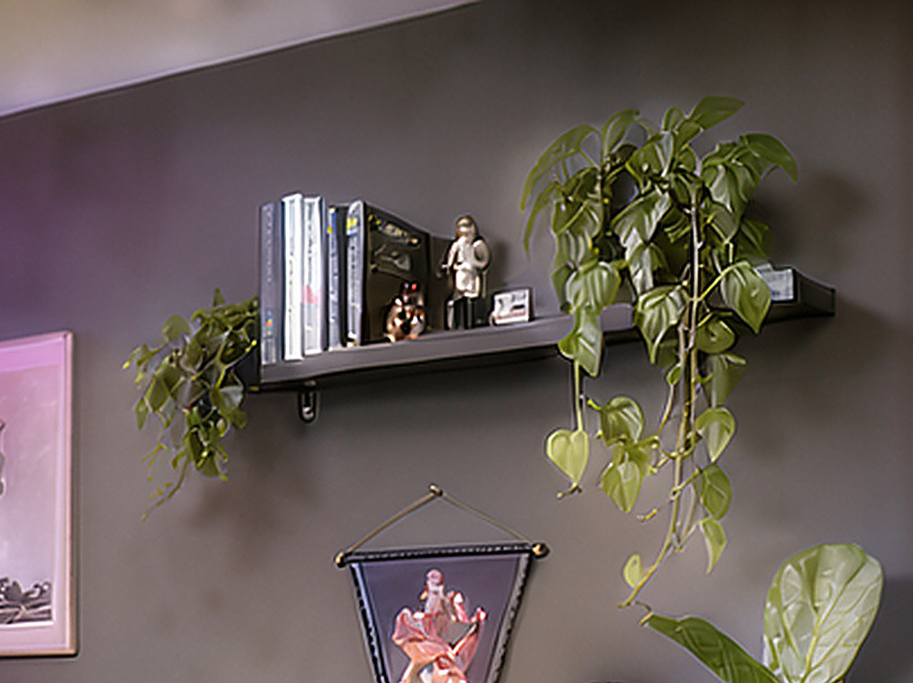 Close-up of the black floating shelf holding trailing plants and small collectibles