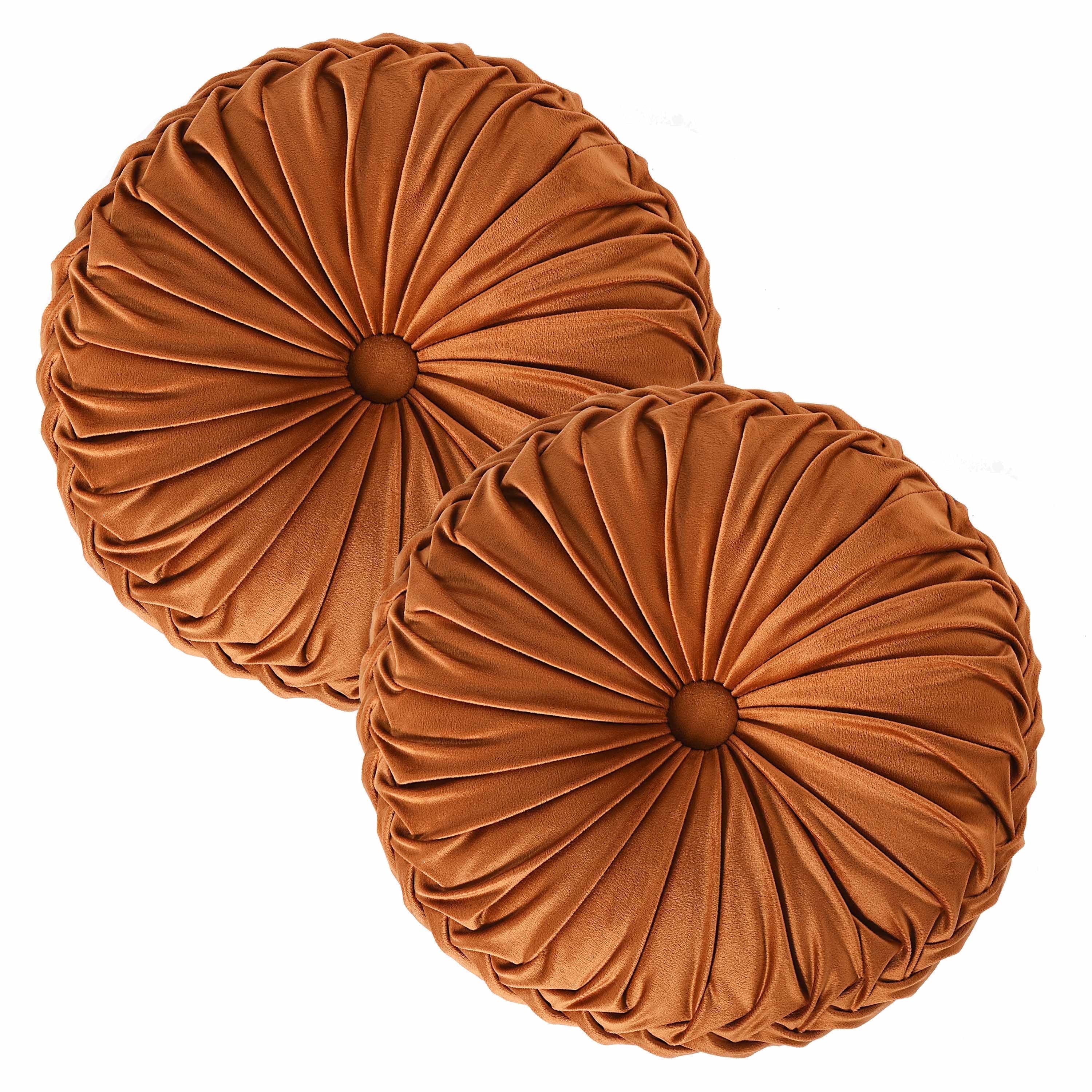Two round, pleated velvet pillows in a rust color are displayed side by side against a white background.