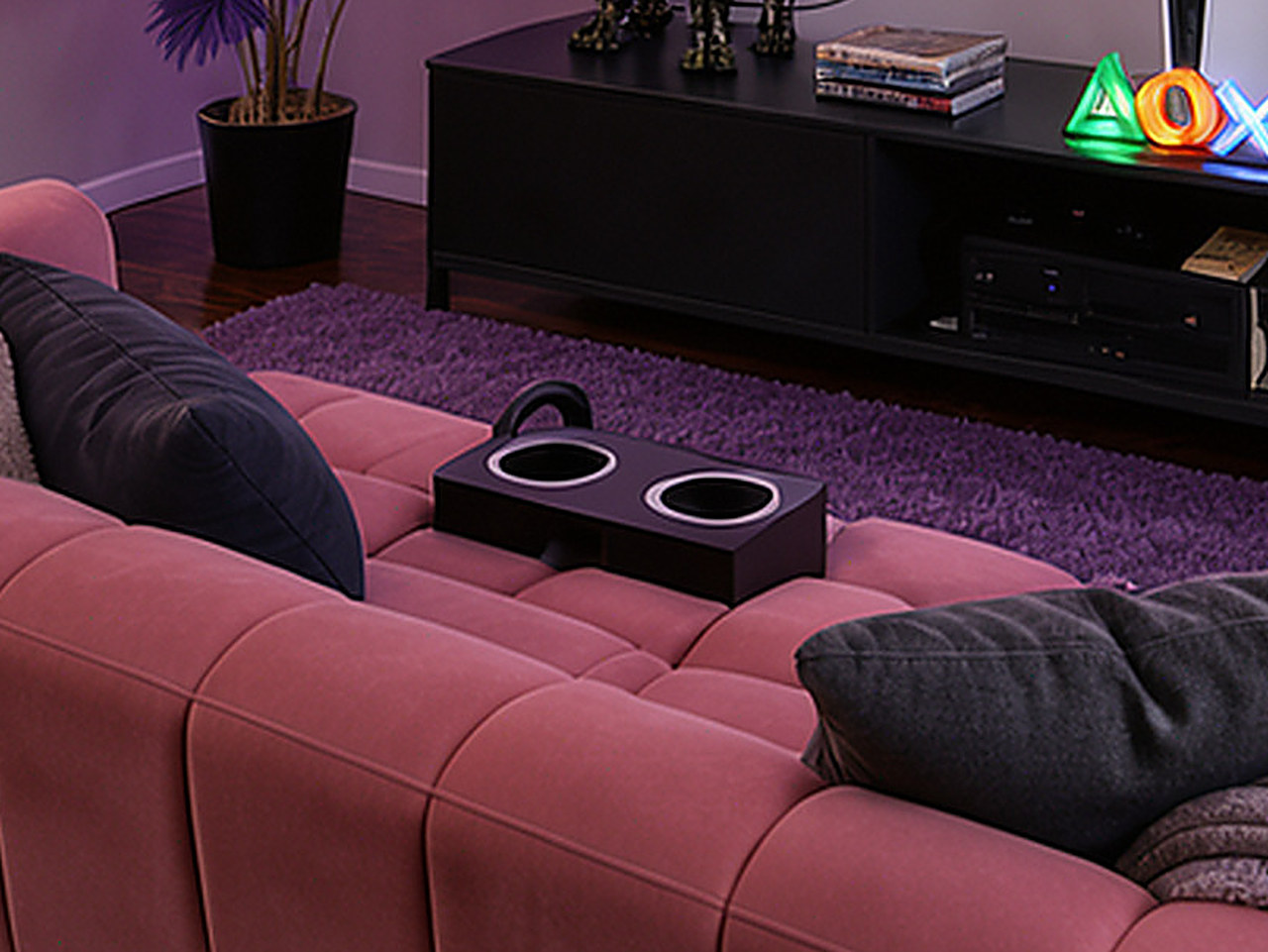 Close-up of the black dual cup holder mounted between the sofa seats.