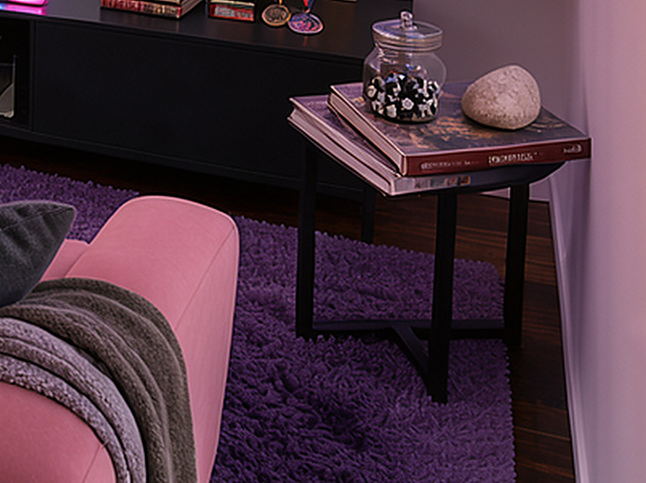 Close-up of the black wooden end table with angled legs and a lower shelf.