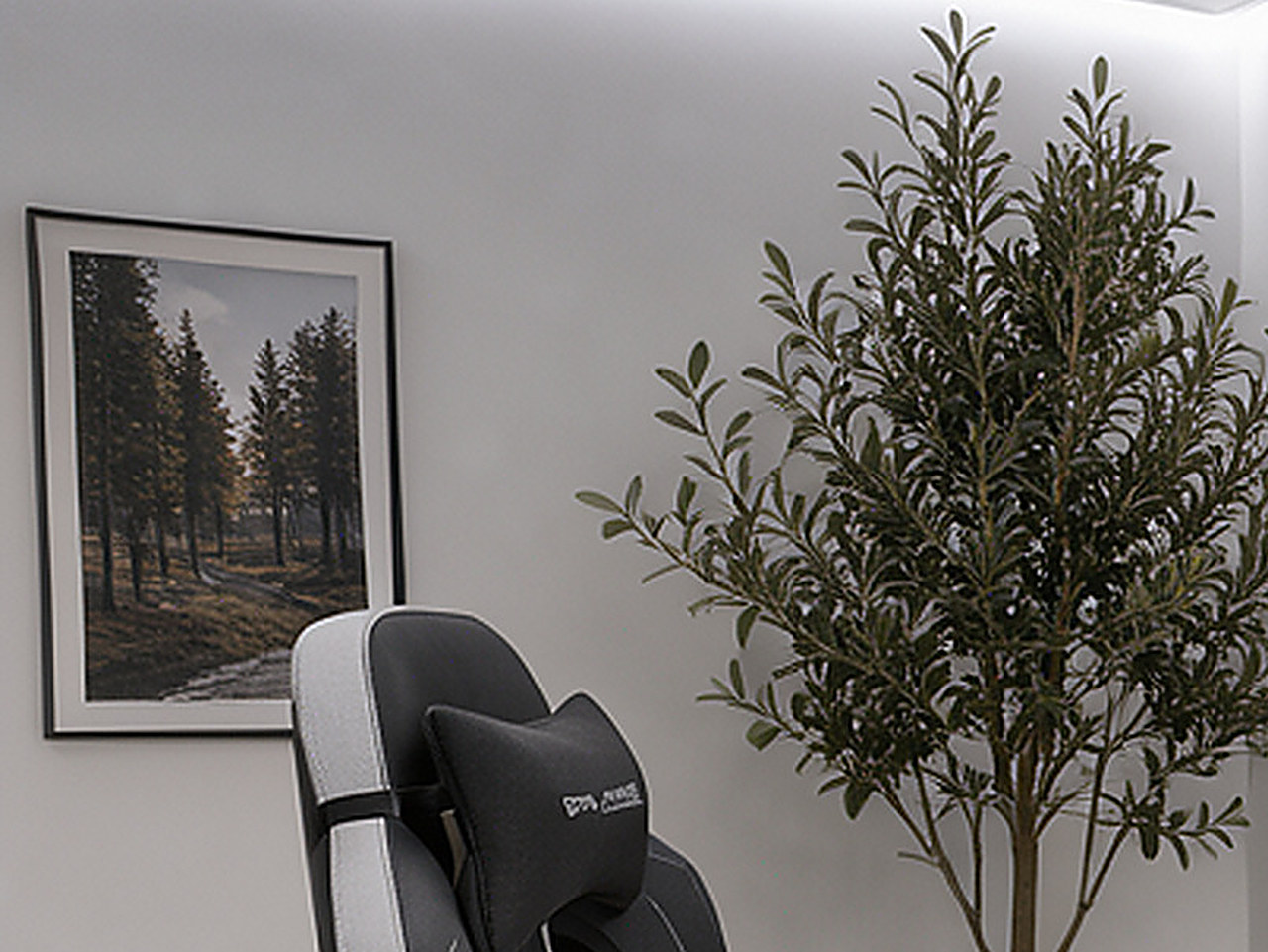 Close-up of the black framed wall art showing the black and white forest landscape with sun rays.