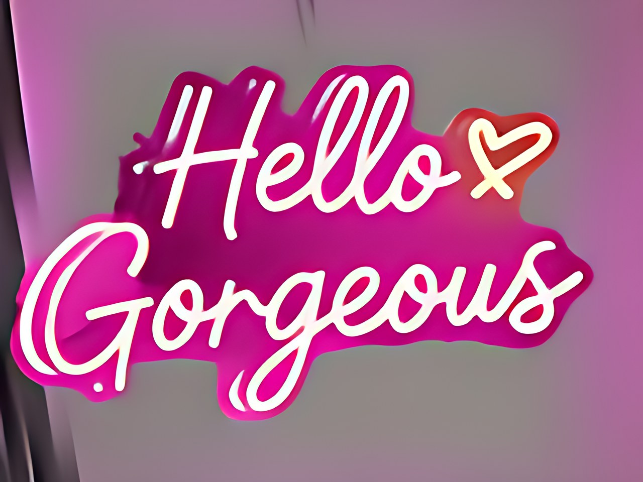 Close-up of a glowing pink neon wall sign with white cursive text.