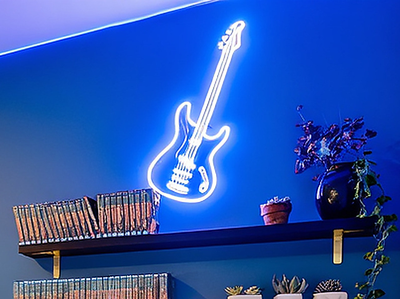 Close-up of the blue bass guitar neon sign glowing on the wall.