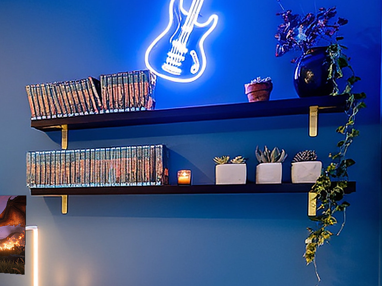 Close-up of five black wood floating shelves with gold brackets holding small decor items.