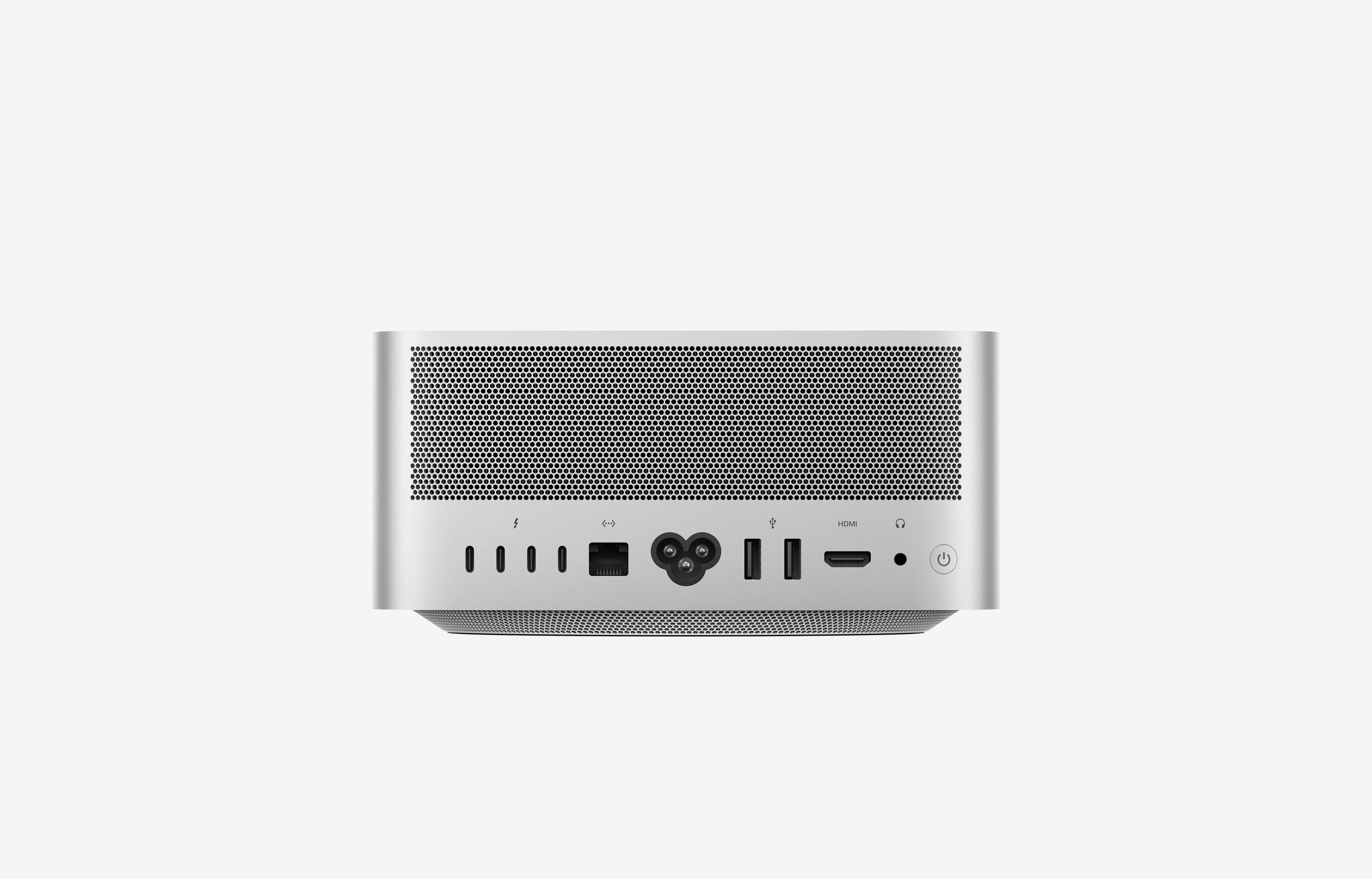 The rear panel of a silver Mac Studio desktop computer with its ports and connectors under a perforated vent.