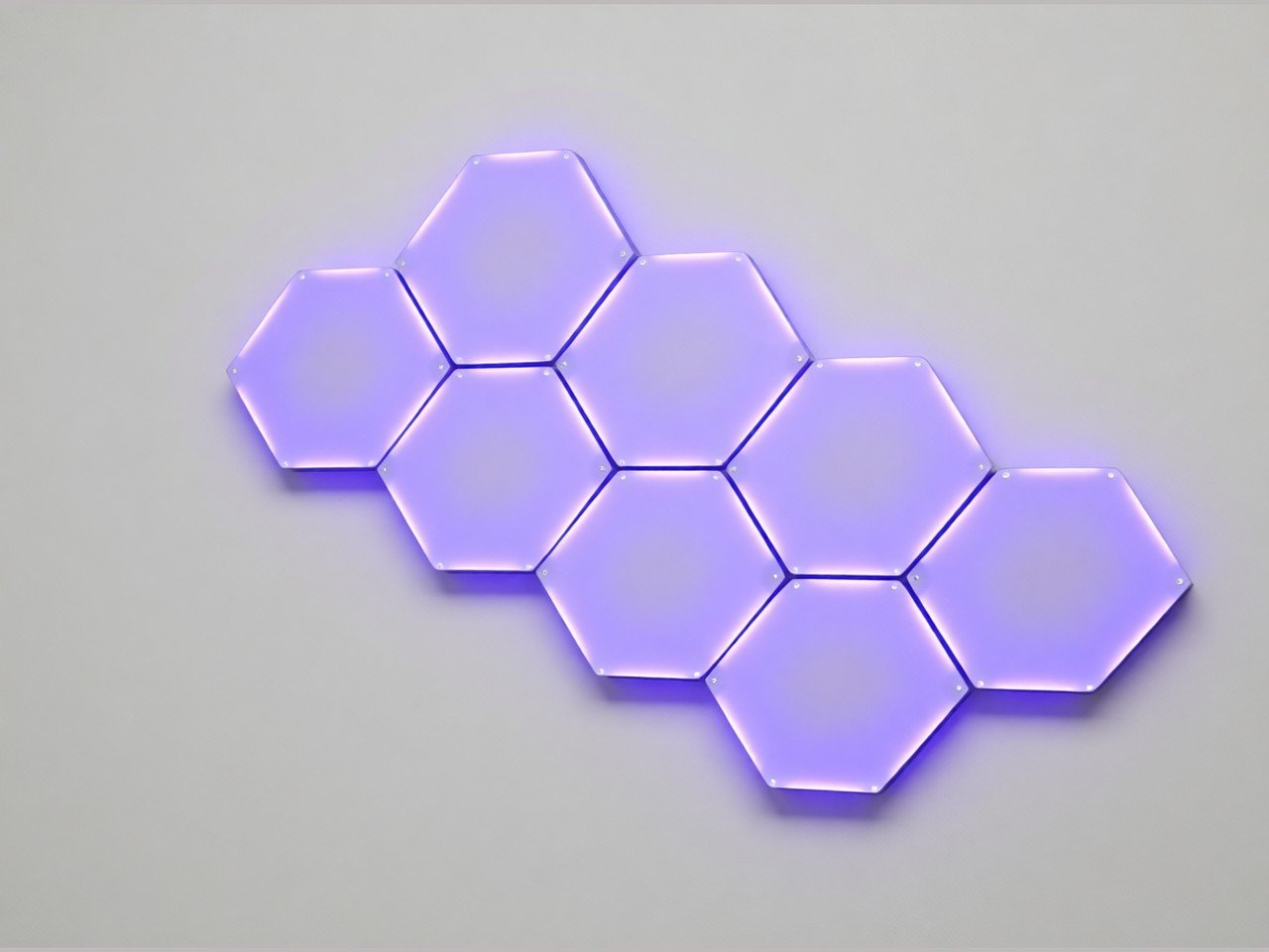 Hexagonal LED light panels glowing purple, shown on a plain grey background.