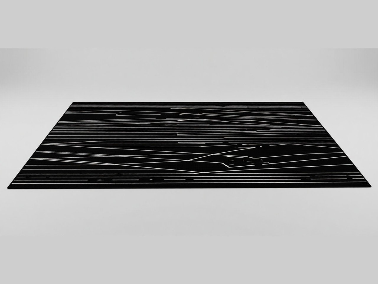 Large rectangular black rug with thin white geometric stripes, shown on a plain grey background.