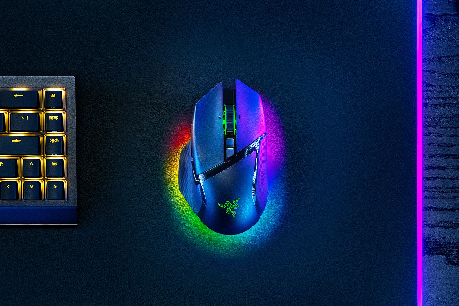 The Razer Basilisk V3 Pro mouse is shown in a top-down view with its illuminated RGB lighting and textured surface.