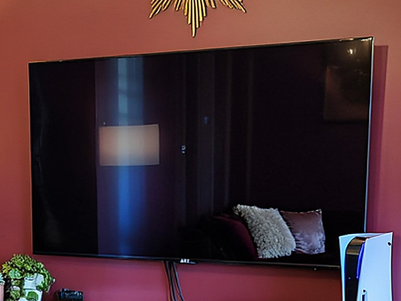 Close-up of the black bezel and screen edge of a wall-mounted television.