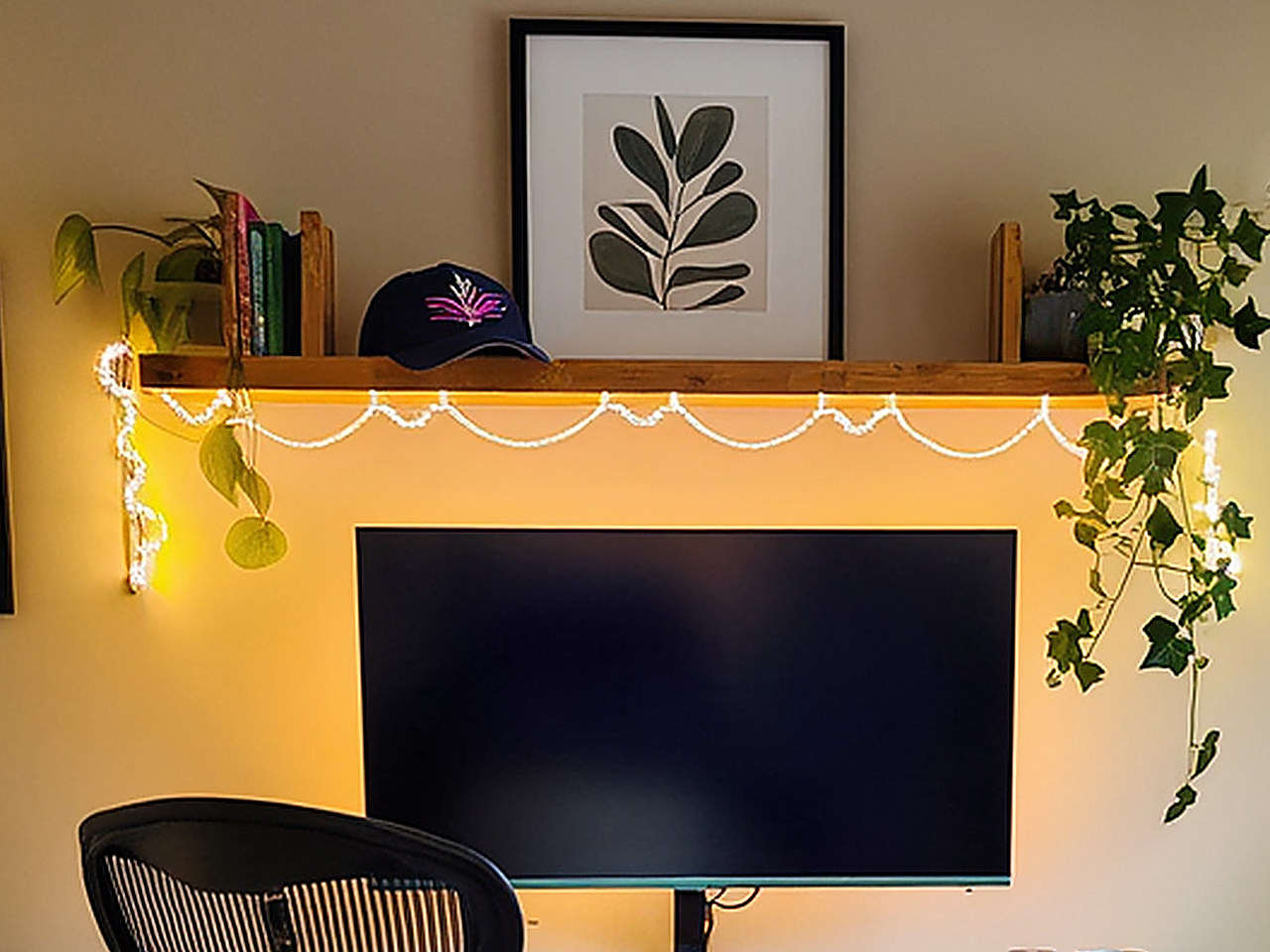 Close-up of warm white glowing LED rope lights draped above a light wood desk.