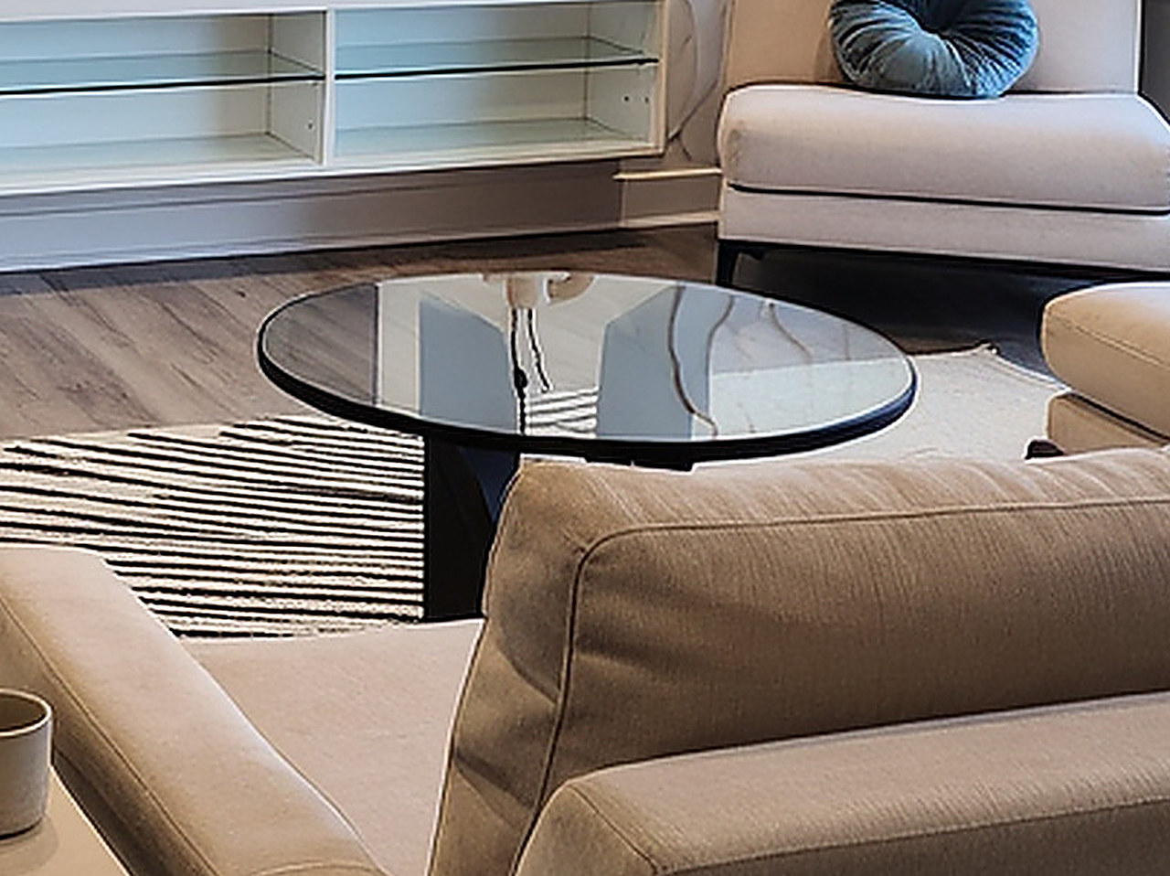 Close-up of the circular glass top coffee table with a black solid wood starburst base.